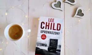 Książka "Uproszczony" Lee Child, filiżanka kawy i ozdobne serca na białym tle.