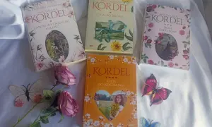 Cztery książki Magdaleny Kordel na białym tle, ozdobione kwiatami i motylami.