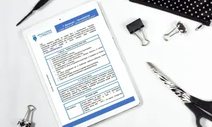 Tablet z notatkami o Tadeuszu Borowskim, pióro, spinacze i nożyczki.