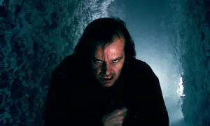 Jack Nicholson z przerażającą miną w ciemnym korytarzu.