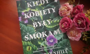 Okładka książki "Kiedy kobiety były smokami" Kelly Barnhill, otoczona bujną zielenią i kwiatami.