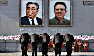Ludzie kłaniają się przed portretami Kim Ir Sena i Kim Dzong Ila, tworząc scenę jak z książek o Korei Północnej.