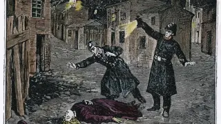 Policjanci oświetlają latarniami mroczną ulicę, gdzie leży ofiara Kuby Rozpruwacza.