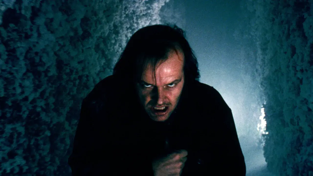 Jack Nicholson z przerażającą miną w ciemnym korytarzu.
