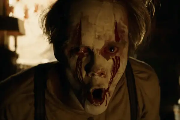 Przerażająca twarz klauna z krwawiącymi oczami, idealna do rankingu horror top 10.