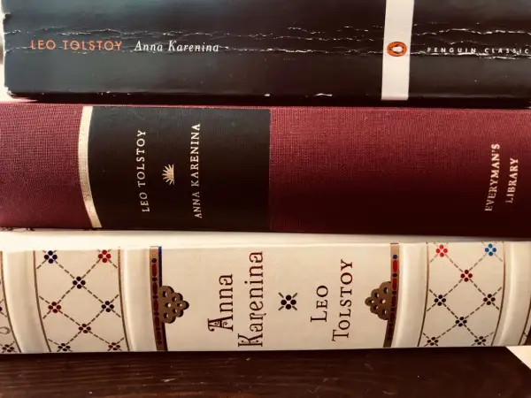Trzy oprawione książki z tytułem "Anna Karenina" i nazwiskiem Lwa Tołstoja.